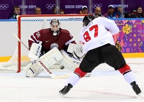 SOCHI, RUSSIA - FEBRUARY 19: Canada's Sidney Crosby #87 shoots the puck against Latvia's Kristers Gudlevskis #50 during men's quarterfinal round action at the Sochi 2014 Olympic Winter Games. (Photo by Andre Ringuette/HHOF-IIHF Images)